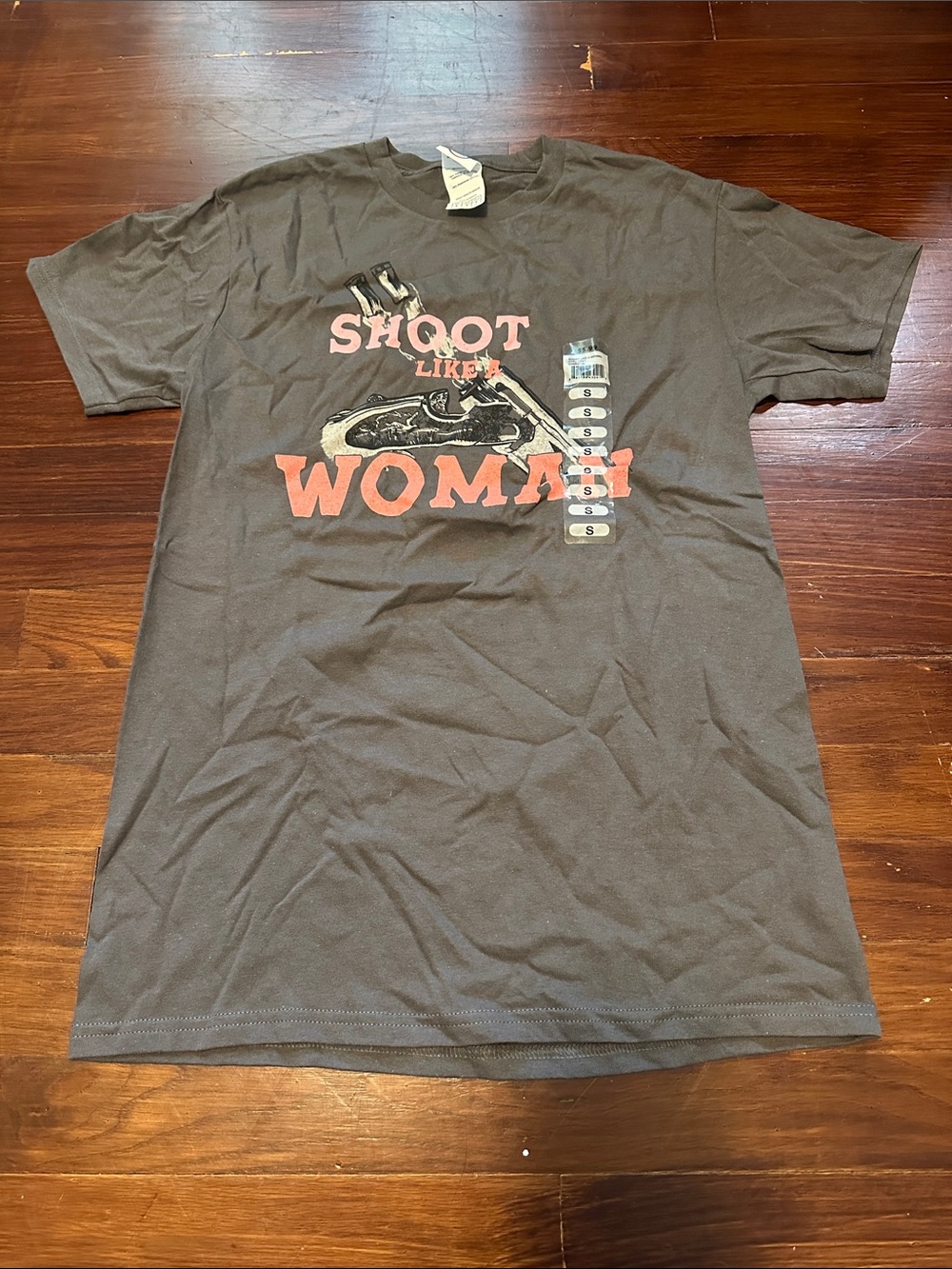 Gray Short Sleeve Graphic Tee with “Shoot Like a Women” Text. SMALL